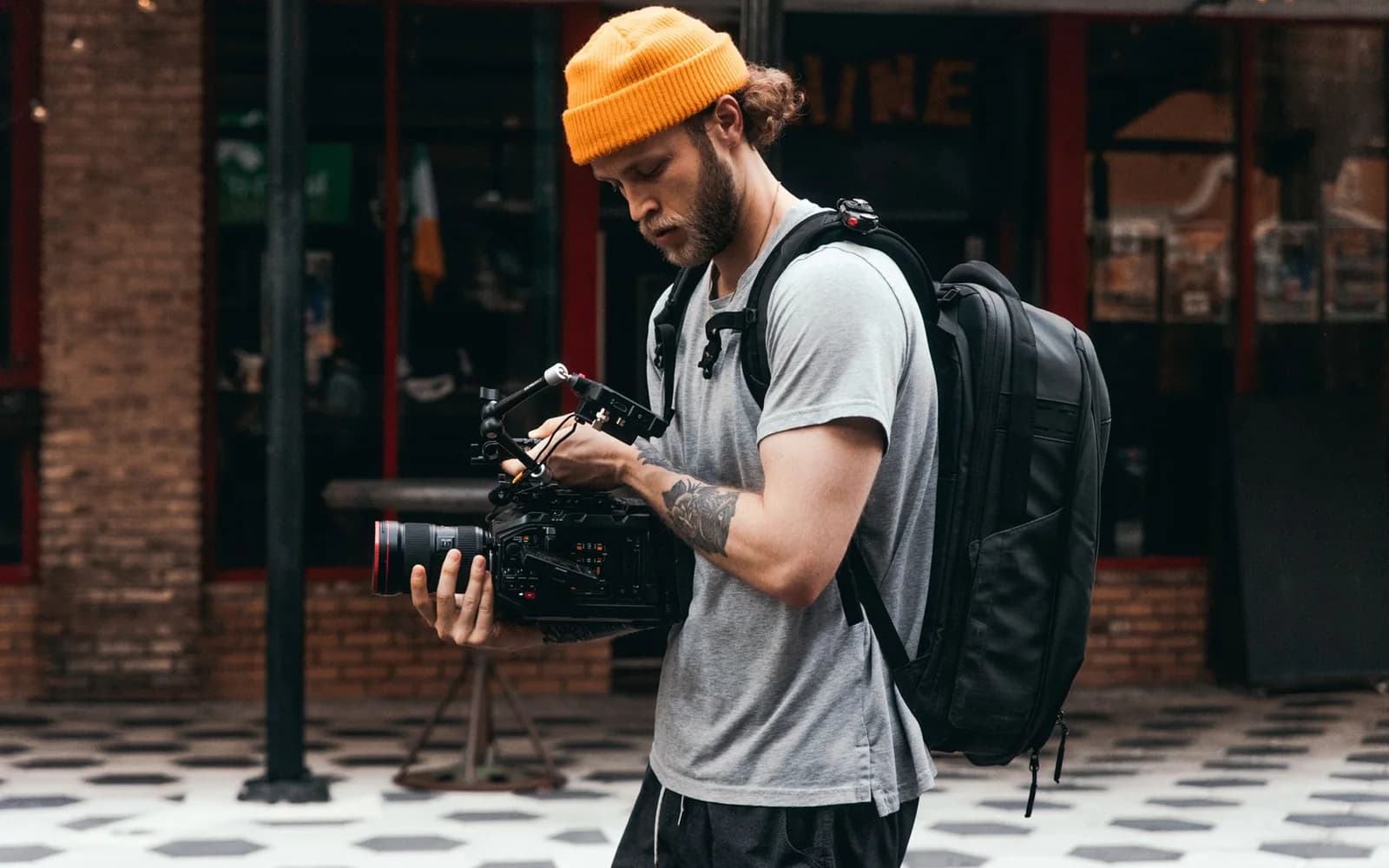 A camera operator checks professional filming equipment on a city street