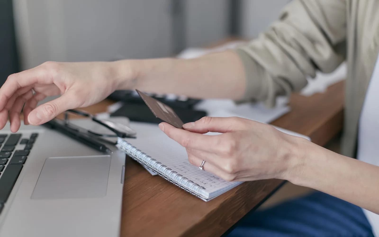 Editorial photograph: Person in Gray Long Sleeves Holding a Credit Card
