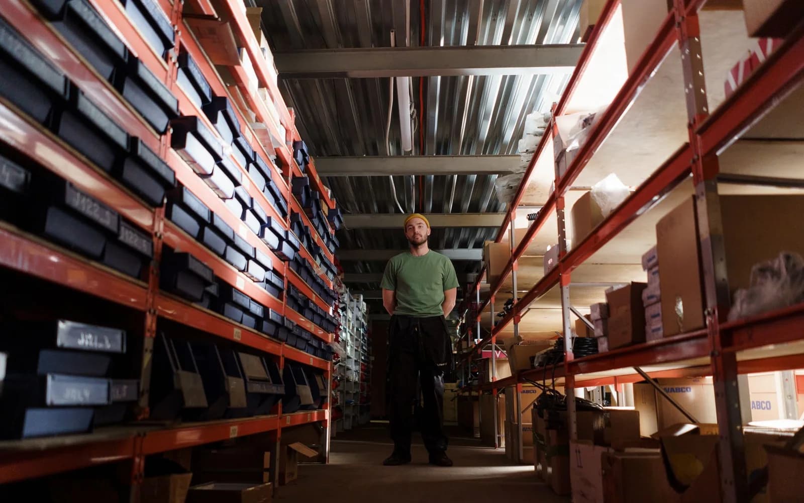 Editorial photograph: Man in green Shirt Standing in the Storeroom