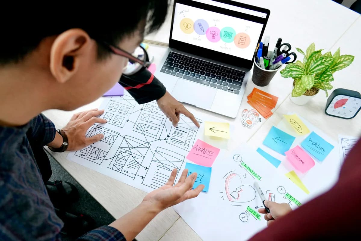 Diseñadores revisan bocetos de interfaces