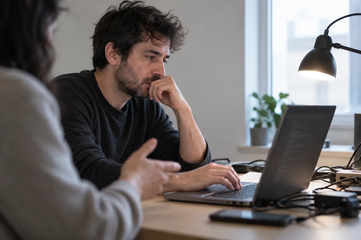 Illustration assistée par IA de développeurs examinant un processus sur ordinateur ; ce ne sont pas des employés d’OpenAI