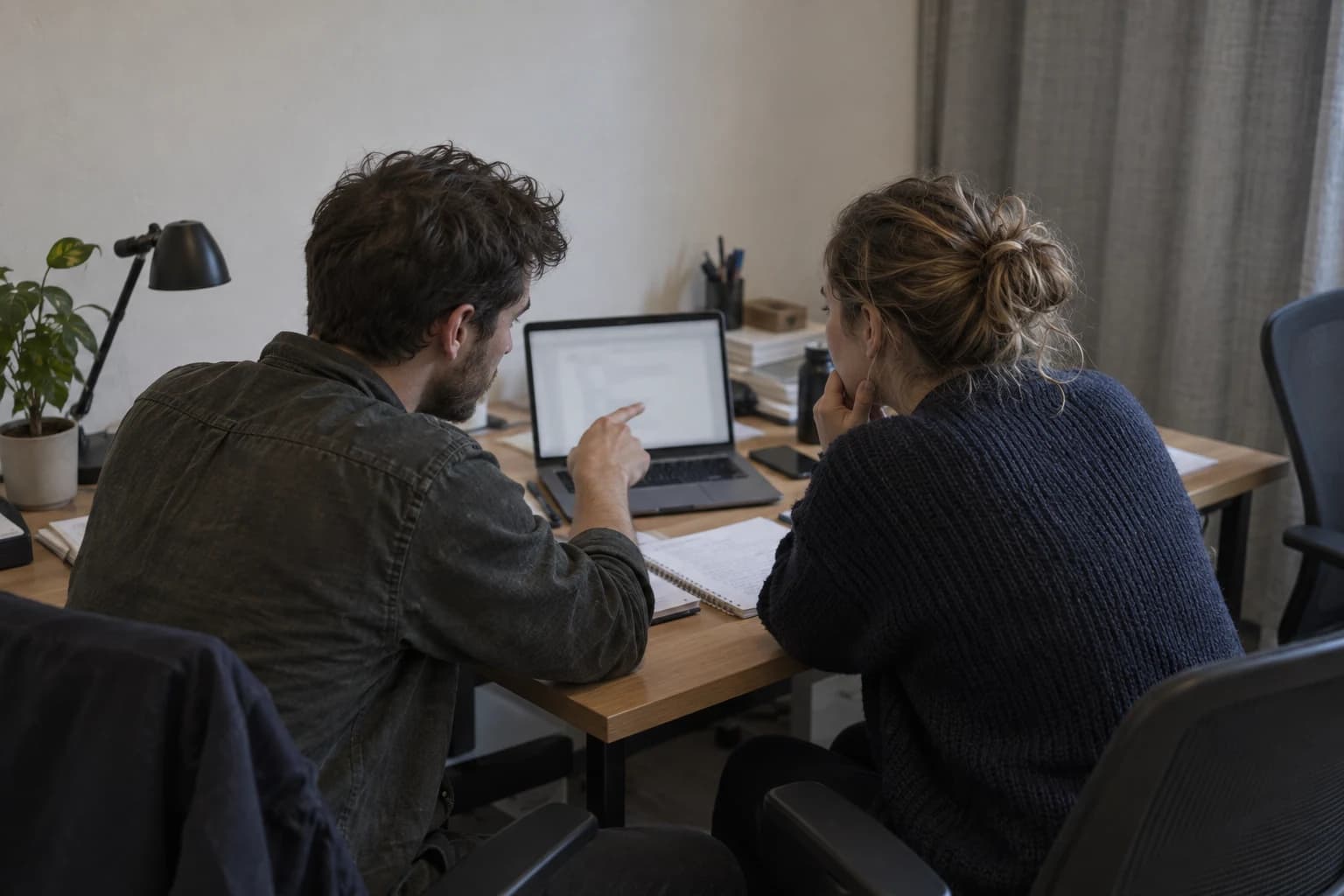 AI-assisted illustration of two editors reviewing a draft at a desk; not VITON13 staff