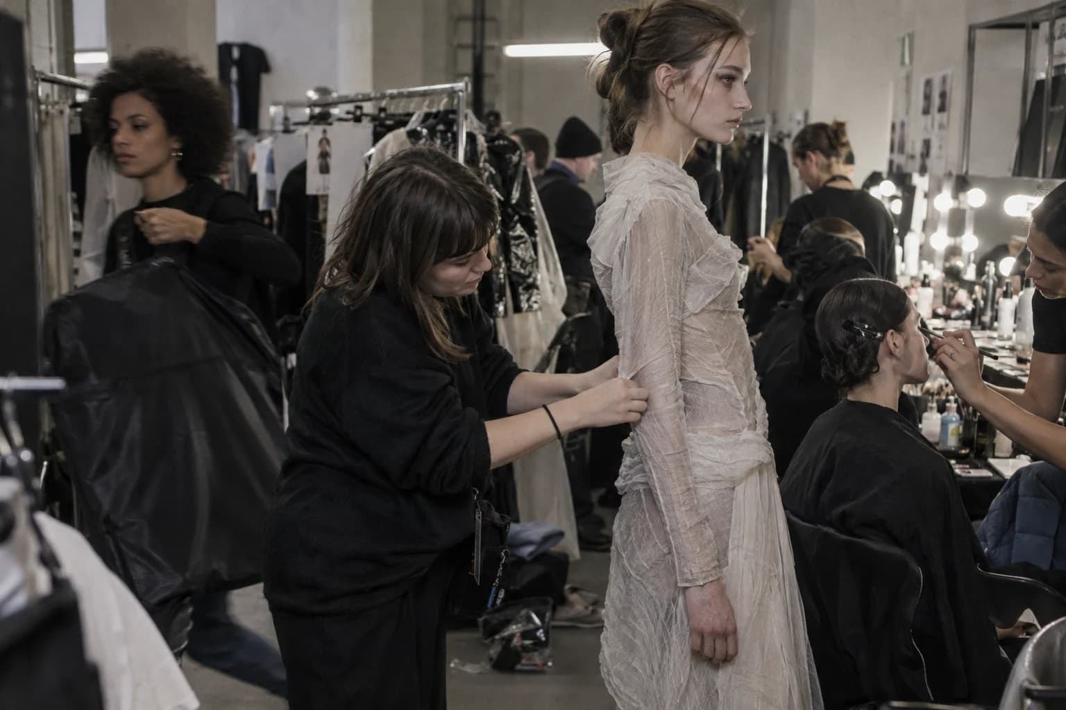 Illustration assistée par IA de stylistes préparant un mannequin ; ce n’est pas une photo d’un défilé de 2026