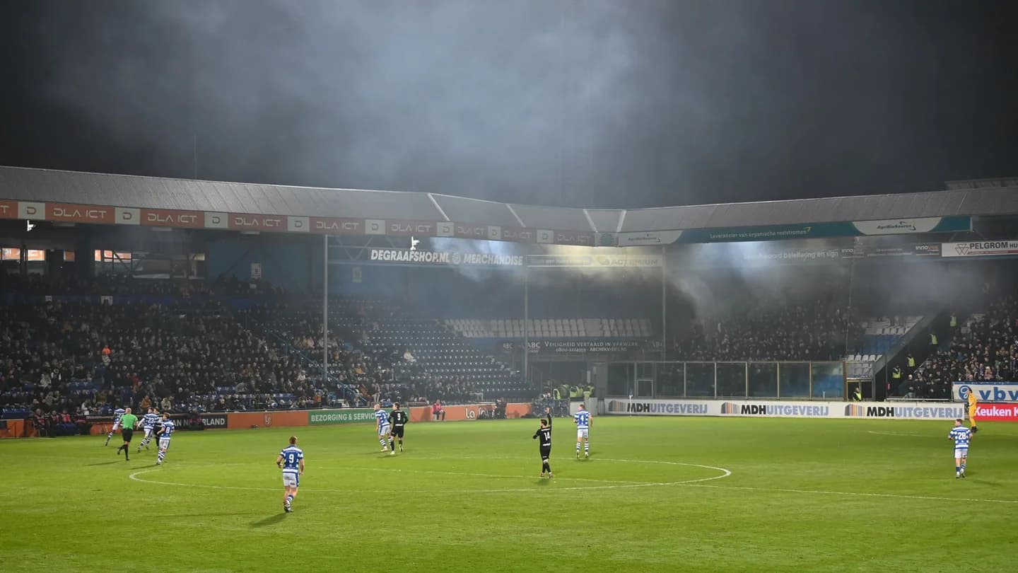Footballers on a floodlit pitch in a small stadium veiled in smoke; illustrative photo, not from the Ballon d'Or or any nominee's match