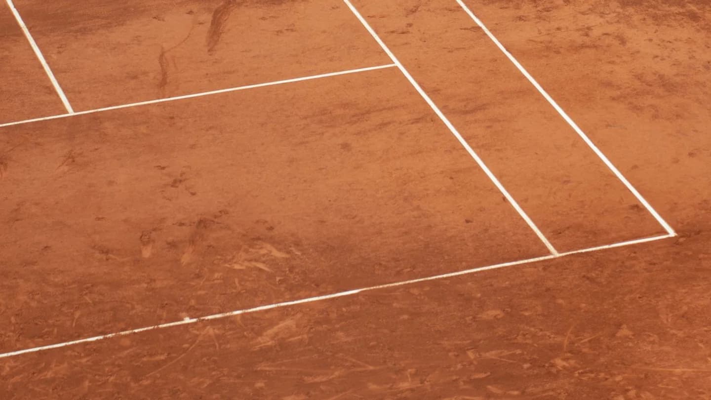 White chalk lines on an empty clay tennis court; illustrative photo, not taken at the US Open, which is played on hard courts