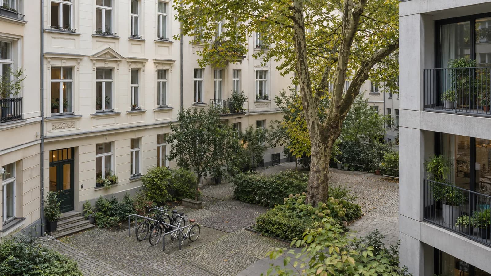 Conceptual AI illustration of a German apartment courtyard with stucco facades, bicycles and a modern residential building.