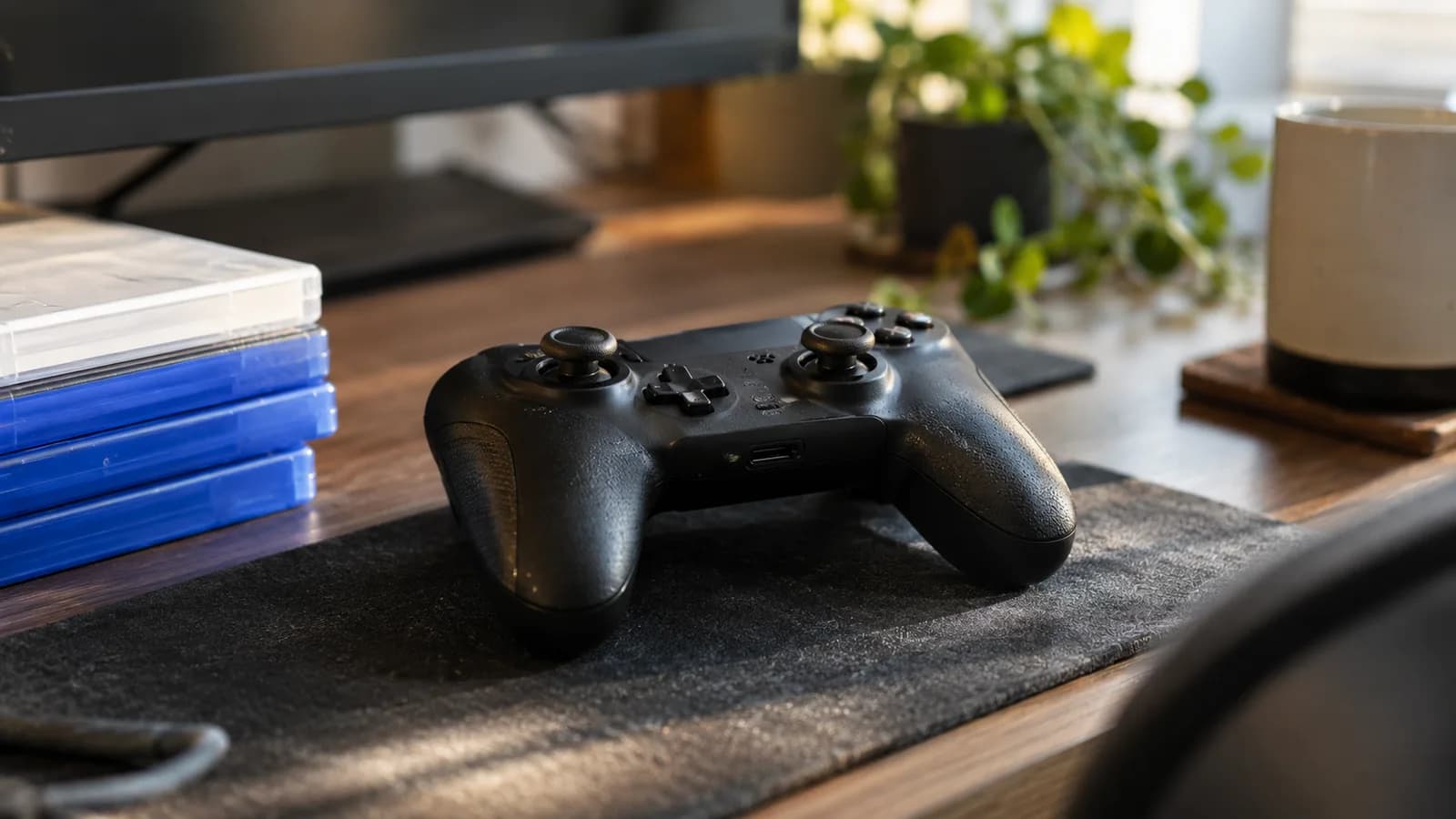 AI conceptual illustration of a generic black game controller, plain game cases and a dark monitor on a daylight gaming desk; no Steam interface.