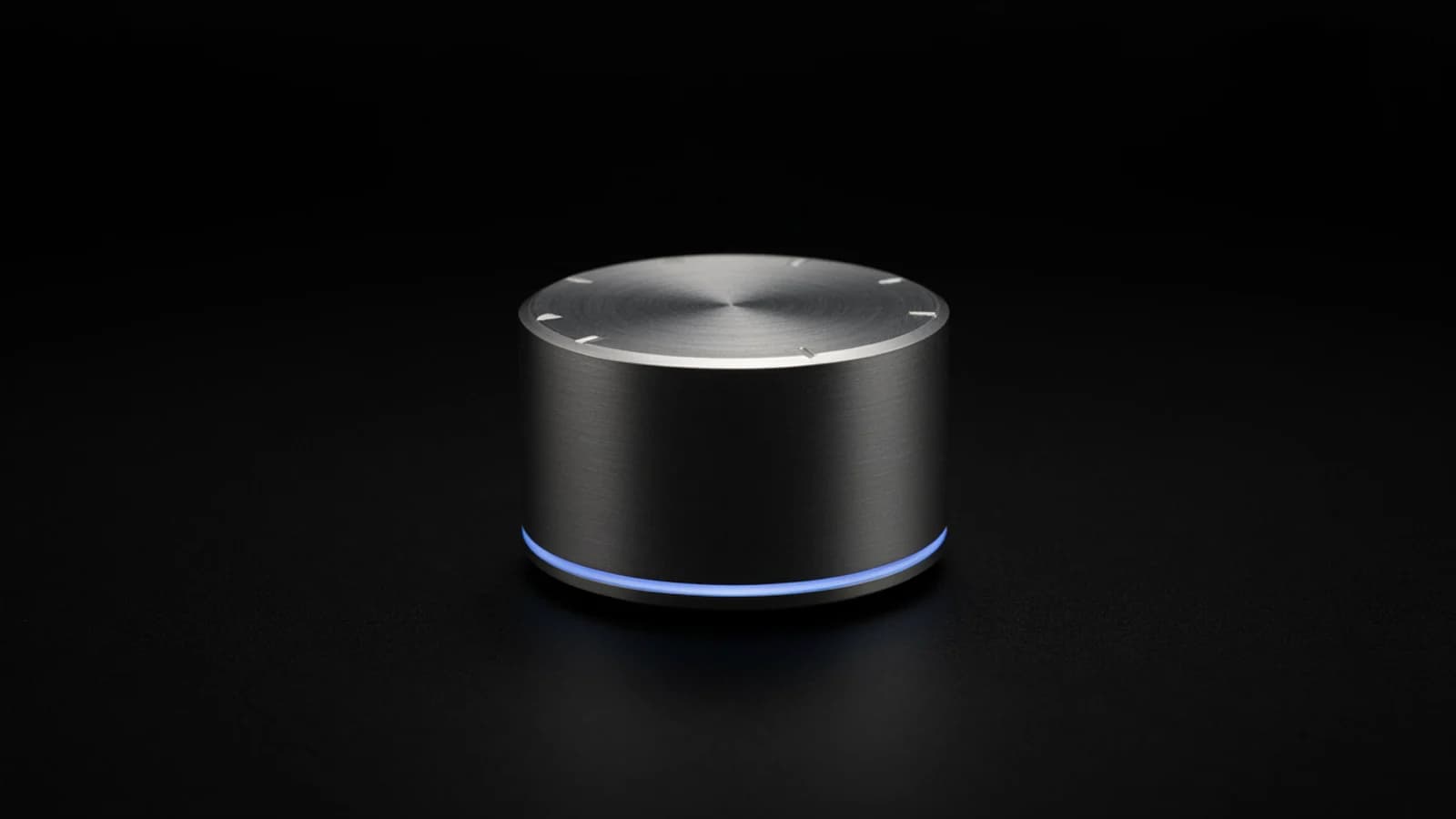 A brushed aluminium control knob with notches on top and a thin sky-blue light ring at its base, on a plain black background; AI-generated image